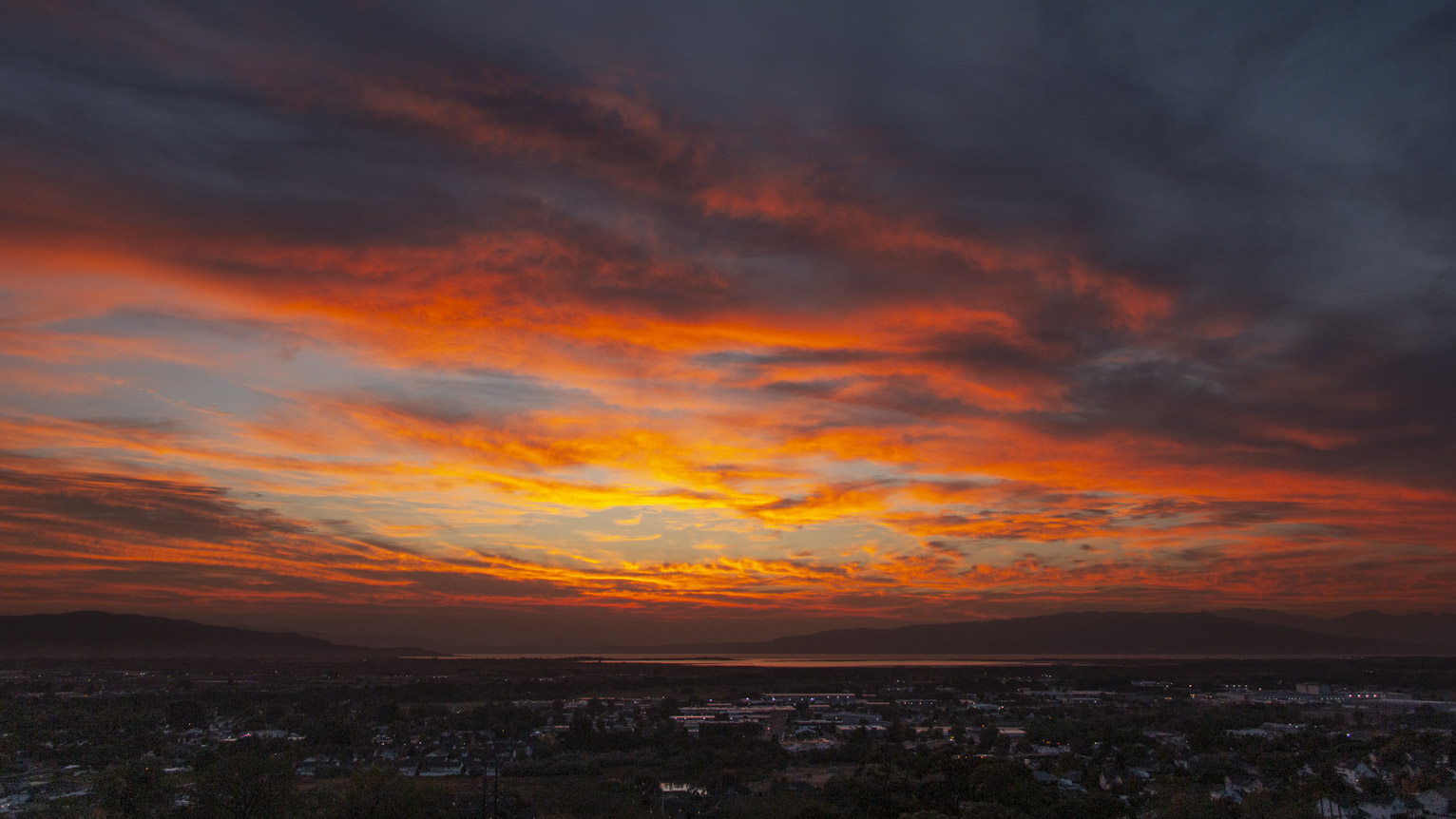 brilliantly orange lit clouds over a town